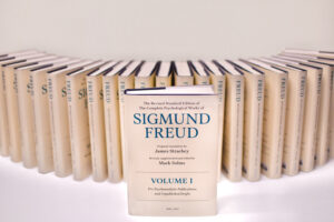 A row of books with one copy positioned in front. The book is titled The Revised Standard Edition of the Complete Psychological Works of Sigmund Freud